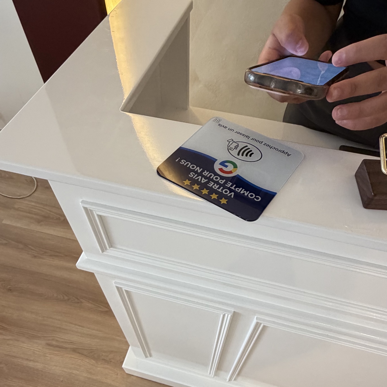 Photo de la plaquette NFC LocalHunter sur un comptoir d'accueil