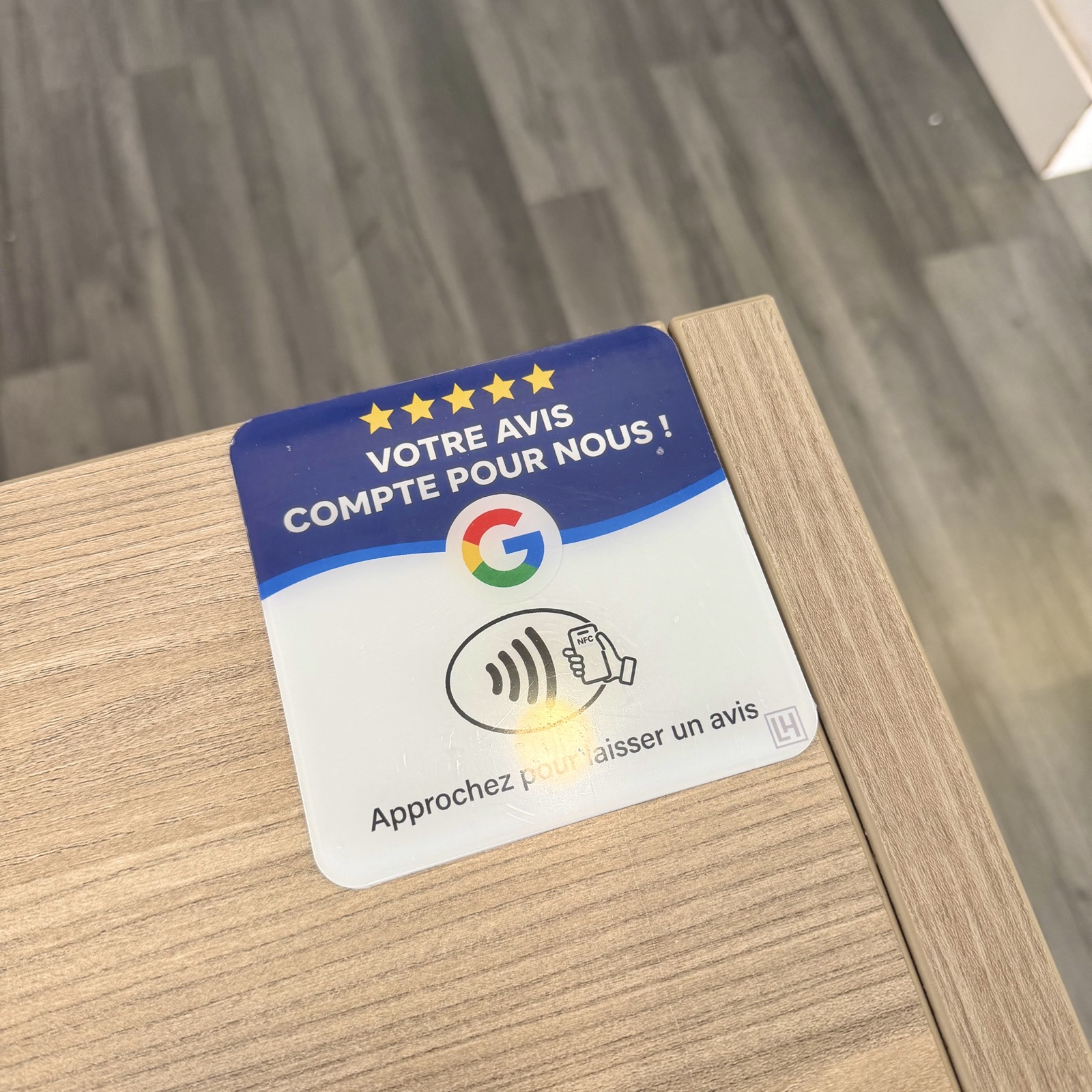 Photo de la plaquette NFC LocalHunter installée en angle de comptoir